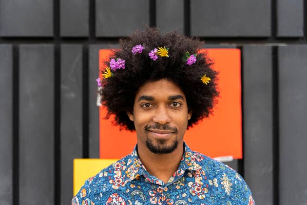 Portrait of man with blossoms in his hair wearing colorful shirt model released Symbolfoto  AFVF03880