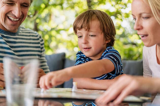 Happy parents and son playing a board game on terrace model released Symbolfoto property released  DIGF08136