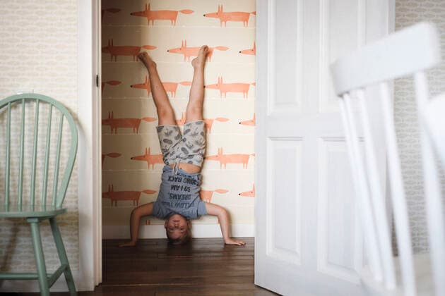 Boy doing a headstand at home model released Symbolfoto property released  EYAF00318