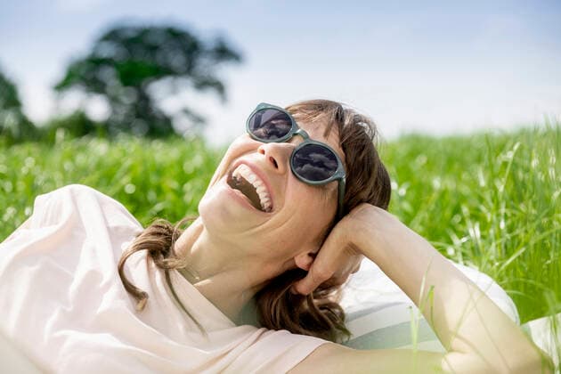 Creative Highlights Symbolfotos Portrait of laughing relaxed woman lying on a meadow model released Symbolfoto  FMKF05769
