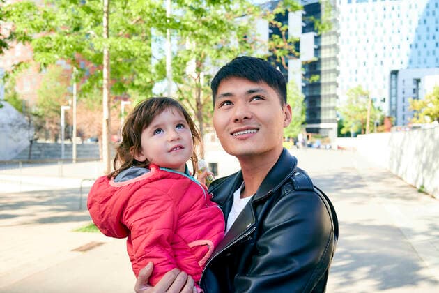 Smiling father holding little daughter looking up model released Symbolfoto  GEMF03091