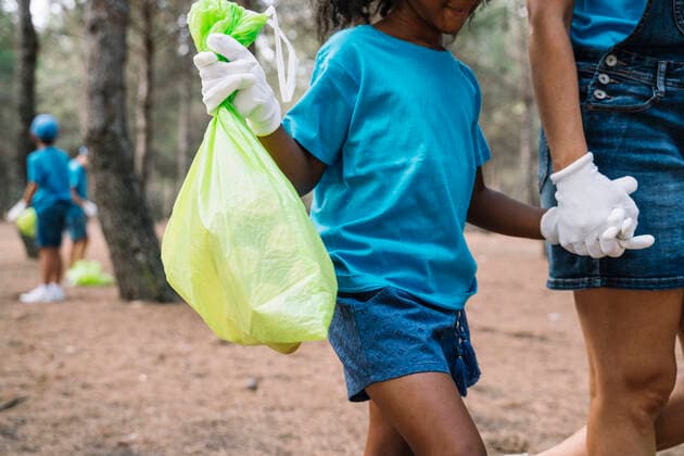 IMAGO Creative: Zivildienst und ehrenamtliches Engagement Woman and girl walking hand in hand collecting garbage in a park model released Symbolfoto  JCMF00097