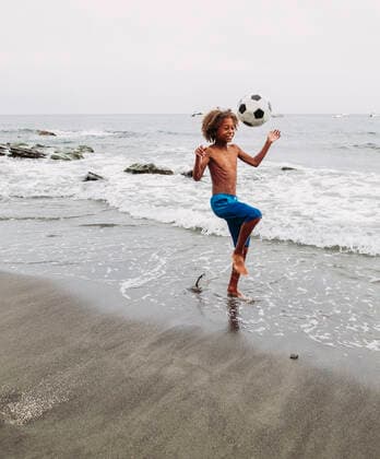 Freizeit Trend: Football Freestyle Boy playing with a football on the beach model released Symbolfoto  LJF00988