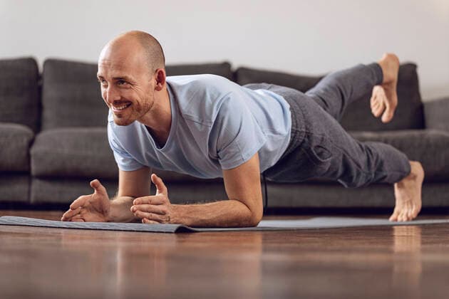 Man doing gymnastics at home model released Symbolfoto property released  MCF00306
