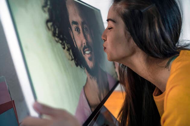 Young woman kissing man on computer screen model released Symbolfoto property released  RIBF01053