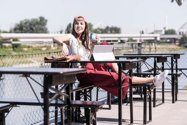 Young woman relaxing in a beer garden looking around model released Symbolfoto  UUF18445