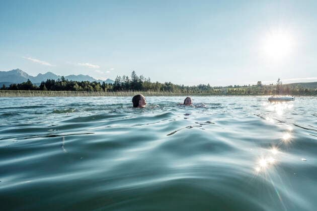 Two girls swimming in a lake in sunshine, Bannwaldsee, Allgaeu, Bavaria, Germany model released Symbolfoto  WFF00088