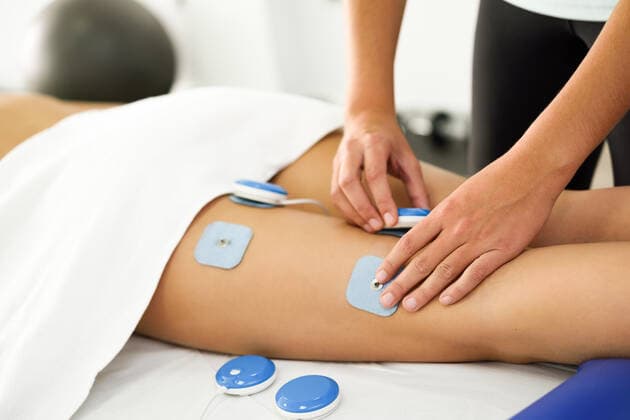 Physiotherapist applying electro stimulation in physical therapy to a young woman. Medical check at the leg in a physiotherapy center.,model released, Symbolfoto,property released ING_18944_04826