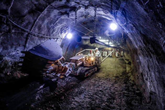 01.10.2019, Recklinghausen, Ruhrgebiet, Nordrhein-Westfalen, Deutschland - Steinkohle-Erlebnisbergwerk Recklinghausen, das Trainingsbergwerk Recklinghausen wird das groesste Besucherbergwerk fuer Steinkohle in Deutschland, Fuehrung einer Besuchergruppe, Besucher koennen an Maschinen und Werkzeugen alles selbst ausprobieren, hier am Raupenbagger. Recklinghausen Nordrhein-Westfalen Deutschland
