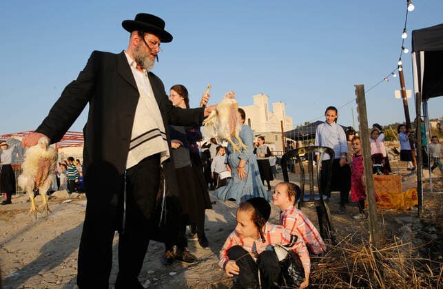 (191007) -- BEIT SHEMESH, Oct. 7, 2019 -- Ultra-Orthodox Jews perform the Kaparot ritual, where white chickens are slaughtered as a symbolic gesture of atonement, ahead of Yom Kippur, the Jewish Day of Atonement, in Beit Shemesh, Israel, Oct. 6, 2019. (Photo by Gil Cohen Magen Xinhua) ISRAEL-BEIT SHEMESH-KAPAROT GuoxYu 