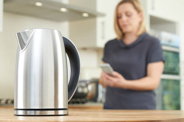 IMAGO Creative: Haushaltsgeräte - Wasserkocher Woman Controlling Smart Kettle Using App On Mobile Phone,model released, Symbolfoto,property released ING_39524_04756