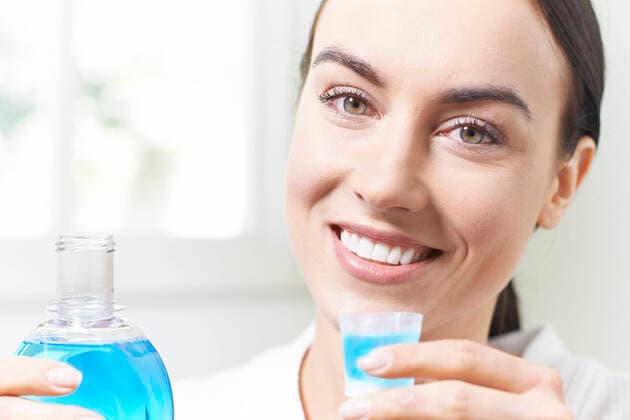 Portrait Of Woman With Beautiful Teeth Using Mouthwash In Bathroom,model released, Symbolfoto ING_39524_05739