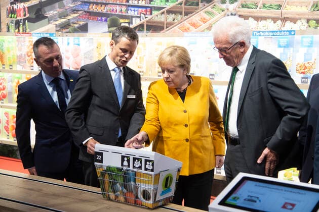 Bundeskanzlerin Angela MERKEL, CDU, Dr. Bernd WELZ, Vorstandsmitglied der Klimastiftung, Winfried KRETSCHMANN, Buendnis 90 die Gruenen, Ministerpraesident des Landes Baden WUERTTEMBERG, besuchen einen Klimasupermarkt, Rundgang durch die Ausstellung, Eroeffnung der Klima-Arena in Sinsheim, 07.10.2019, *** Federal Chancellor Angela MERKEL, CDU, Dr Bernd WELZ, Member of the Board of the Climate Foundation, Winfried KRETSCHMANN, Buendnis 90 die Gruenen, State Premier of Baden WUERTTEMBERG, visit a climate supermarket, tour of the exhibition, opening of the Climate Arena in Sinsheim, 07 10 2019,