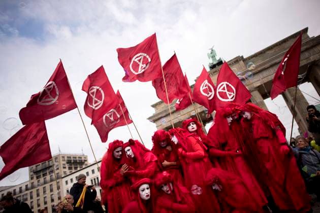 Extinction Rebellion DEU, Deutschland, Germany, Berlin, 11.10.2019 Demonstranten der Gruppe Rote Rebellen Red Rebels auf der Demonstration der Grasswurzelbewegung Extinction Rebellion, XR, unter dem Motto Rebellion gegen das Aussterben, gegen den drohenden Klimakollaps und Das Massive Artensterben am Brandenburger Tor in Berlin. Protest unter dem Einfluss der weltweiten Bewegung FridaysForFuture fuer den Klimaschutz. Environmental Red Rebels activists, a sub-group of the Extinction Rebellion, on a rally of the global environment movement Extinction Rebellion during a protest demanding the government take action on climate change at Brandenburger Gate in Berlin, Germany, 11 October 2019. The protest is influenced by the worldwide movement FridaysForFuture, Fridays for Future, or Global Strike for Future climate protest. The protest is in
