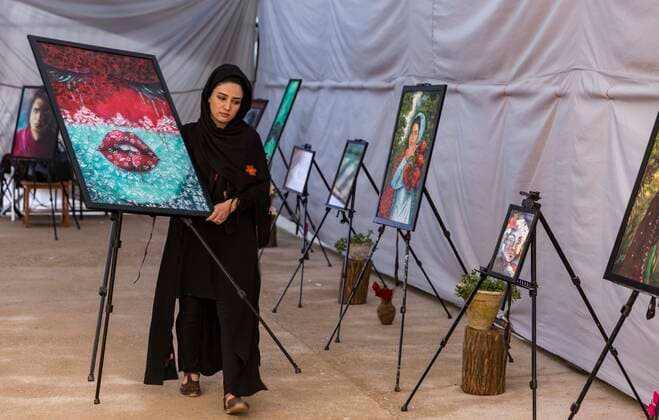 (191014) -- HERAT, Oct. 14, 2019 -- Afghan artist Shekiba Sahrayee arranges her painting works at an exhibition in Herat province, Afghanistan, Oct. 13, 2019. A three-day painting exhibition which shows the challenges that women are facing in the conservative Afghanistan society kicked off in Heart province on Sunday. (Photo by Xinhua) AFGHANISTAN-HERAT-PAINTING EXHIBITION ElahaxSahel 