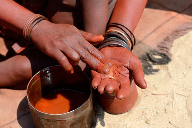 IMAGO Cultures of the world, Himba Volk in Namibia Himba woman mixing ochre with butter to make Otjize, Marienfluss Valley. Kaokoland, Namibia. October 2015  1531126 EricxBaccega