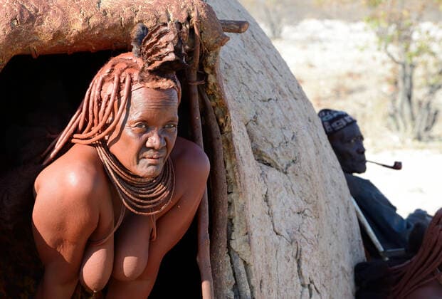 IMAGO Cultures of the world, Himba Volk in Namibia Portrait of Himba woman emerging from her hut, Kaokoland, Namibia October 2015  1531165 EricxBaccega