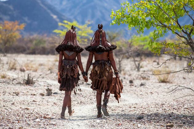 IMAGO Cultures of the world, Himba Volk in Namibia Himba women walking toward a village, Northern Kaokoland, Kunene District, Namibia.  1561645 ChristophexCourteau