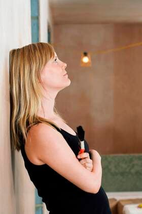 Woman Leaning Against Wall Holding Paint Brush,model released, Symbolfoto,property released 03B74032