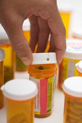 Man s hand opening pill bottle, close-up,model released, Symbolfoto 03B99520