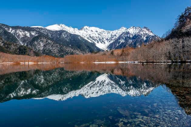  Schneebedeckte Berge an einem See, Japanische Alpen spiegeln sich in Taisho Pond, hinten schneebedeckter Mount Hotaka, Kamikochi, Matsumoto, Nagano, Japan, Asien *** Snow-covered mountains at a lake, Japanese Alps reflected in Taisho Pond, snow-covered Mount Hotaka at the back, Kamikochi, Matsumoto, Nagano, Japan, Asia Copyright: imageBROKER/MoritzxWolf ibxmmw05052135.jpg