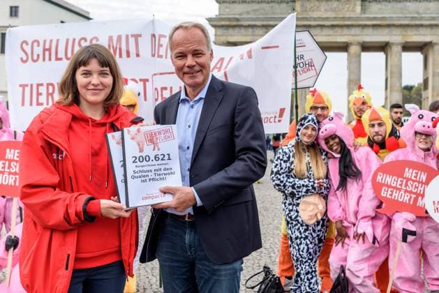 Aktivisten der Bürgerbewegung Campact protestieren am Brandenburger Tor in Berlin gegen das Tierwohl-Label von Agrarministerin Klöckner unter dem Motto Aufstand der Tiere . Die Kennzeichnung ist freiwillig und ist den Tierschutzaktivisten nicht ausreichend. Aktivistin Antonia Becher übergibt Matthias Miersch (MdB, SPD) eine Unterschriftenlistl mit 200.000 Unterschriften für ein verbindliches Tierwohl-Label. Activists of the civic movement Campact are protesting at the Brandenburg Gate in Berlin against the Animal Welfare Label of Agriculture Minister Klöckner under the motto Insurrection of Animals . The labeling is voluntary and is not sufficient for animal welfare activists. Activist Antonia Becher hands Matthias Miersch (MdB, SPD) a signature list with 200,000 signatures for a binding animal welfare label. snapshot-photography F