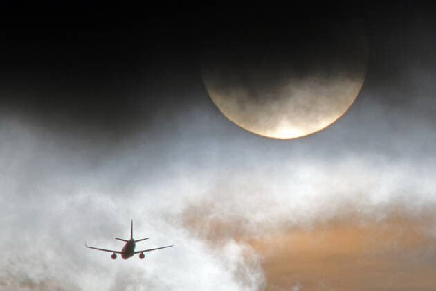 Inlandsflüge und Klimawandel INTERPOLATION: Zwischen Wolkenlücken in der Atmosphäre und der Sonne befindet sich ein Flugzeug nach einem kurzen Inlandsflug kurz vor dem Flughafen Düsseldorf International