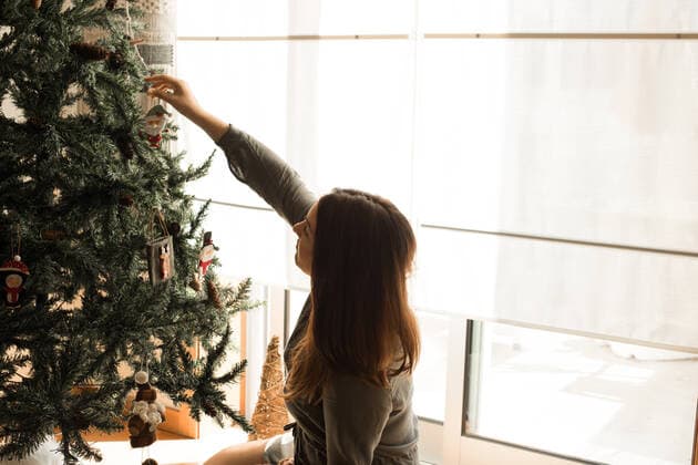 Woman decorating Christmas tree at home,model released, Symbolfoto ING_37293_04562