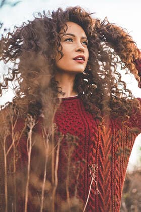 Outdoor lifestyle fashion photo of young natural beautiful lady in autumn landscape with dry flowers. Knitted sweater, wine lipstick. Warm Autumn. Fall vibes,model released, Symbolfoto ING_40696_01458