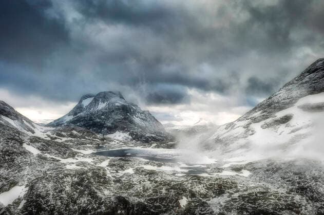 Storm clouds over Olaskarsvatnet lake at feet of the snowcapped Olaskarstind mountain, Venjesdalen valley, Andalsnes, Norway, Scandinavia, Europe Copyright: RobertoxMoiola 1179-3933