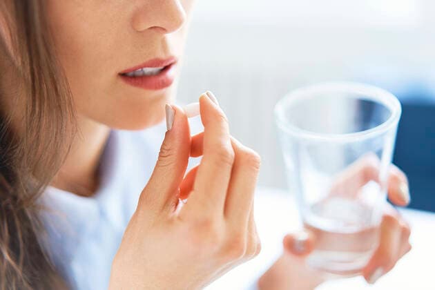 Close up of woman taking pill model released Symbolfoto  BSZF01496