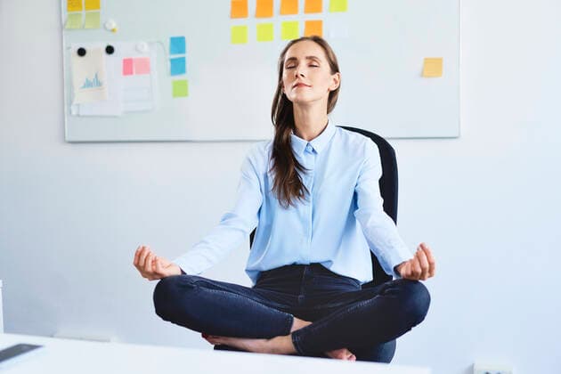 Young businesswoman sitting on office chair meditating model released Symbolfoto  BSZF01503