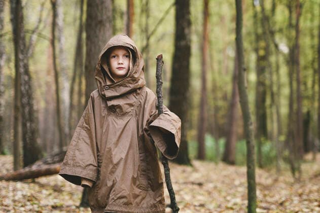 Portrait of boy wearing brown rain coat standing in autumnal forest model released Symbolfoto  EYAF00511