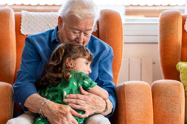 Grandmother hugging her granddaughter in living room model released Symbolfoto property released  GEMF03150