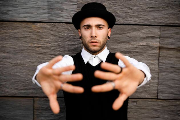 Portrait of serious young man with nose piercing and earrings raising hands model released Symbolfoto  GIOF07037