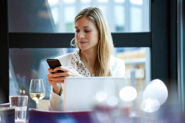 Businesswoman using cell phone in a restaurant model released Symbolfoto property released  JSRF00618