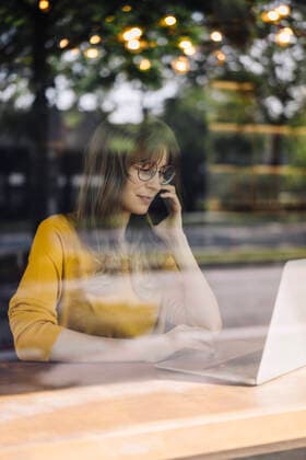Woman with laptop and cell phone in a cafe model released Symbolfoto property released  KNSF06711