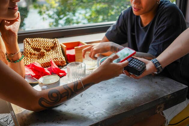 Young woman paying bill with smartphone at coffee shop model released Symbolfoto  MCVF00044