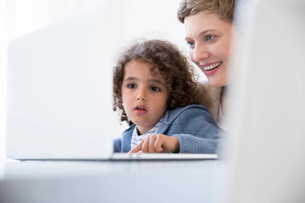 Smiling mother and son using laptop at home model released Symbolfoto property released  MJFKF00149