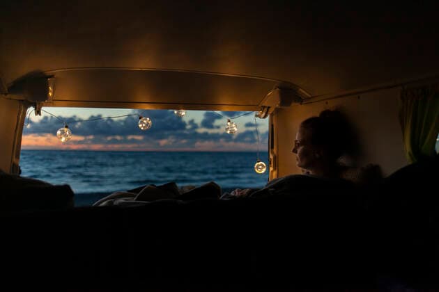 IMAGO Creative: Herbst, Touren mit dem Camper IMAGO Creative: Herbst, Gemütliches Zuhause Woman in a van looking sideways at sunset model released Symbolfoto  NAF00146