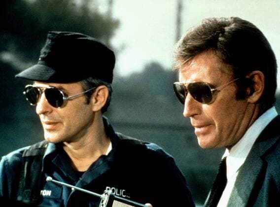 John Cassavetes, Charlton Heston Characters: Sgt. Chris Button,Capt. Peter Holly Film: Two Minute Warning (1977) Director: Larry Peerce 12 November 1976  Copyright: UniversalxAFxArchivexMaryxEvans 12450267 editorial use only