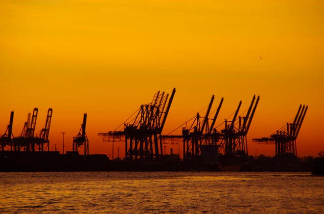 Feature Export und Import, deutsche Wirtschaft: Containerbrücken im Hamburger Hafen im Sonnenuntergang.