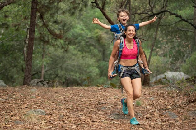 Mom running with his toddler in a backpack on a forrest at Huasca de Ocampo, Mexico Mexico, Hidalgo, Huasca de Ocampo CR_DLAF191014-114910-01