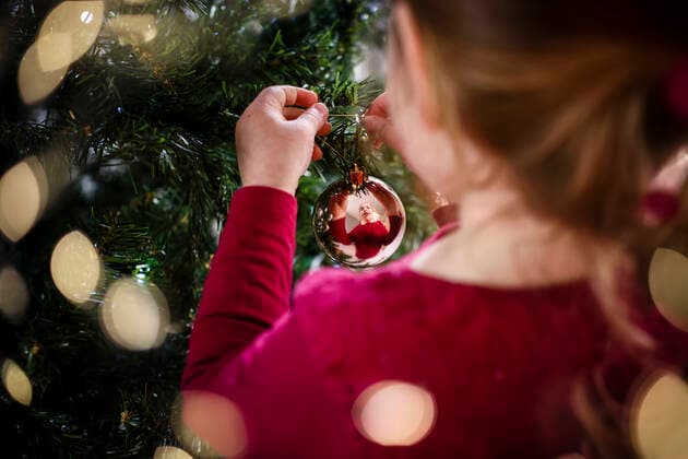 Festive image of girl decorating Christmas tree reflection in bauble France, Occitanie, Montpellier CR_JIBA191016-224629-01