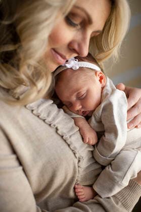 Mother happily holds newborn daughter against her chest at home United States, Colorado, Colorado Springs CR_LIPF190930B-191062-01