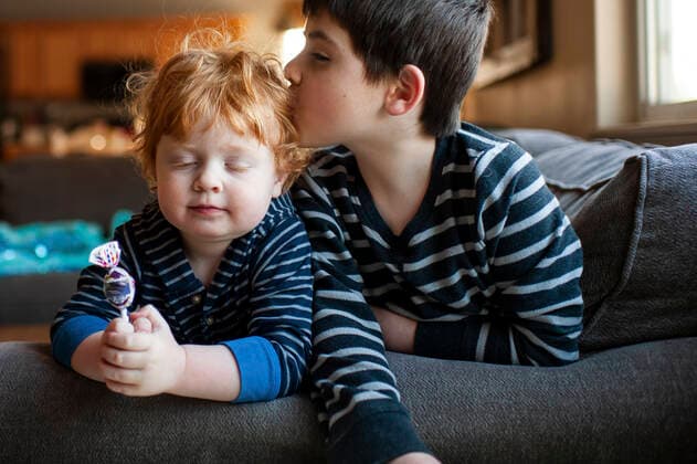 IMAGO Kreativ: Bruderschaft Brother kissing his little brother on the head on couch at home United States, Iowa, Grimes CR_LIPF191008C-213752-01