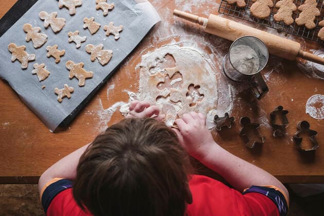 Looking down at boy cutting out gingerbread from dough New Zealand, Taranaki, Hawera CR_LVBS191016-207964-01