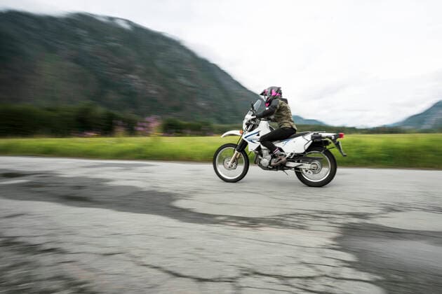 A woman rides her motorcycle on a cloudy summer day. Canada, British Columbia, Pemberton CR_PSFZ191008B-161842-01