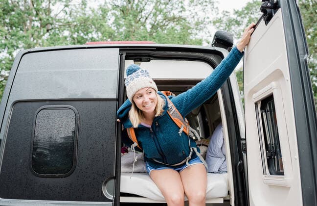 IMAGO Creative, Jahreszeit Herbst, Ferien portrait of blonde woman looking out a camper van camping in the rain Sweden, Stockholm County, Norrtälje CR_RABE191011-182197-01
