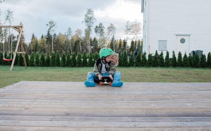 brother and sister playing on a skateboard in a garden having fun Sweden, Stockholm County, Norrtälje CR_RABE191028B-222365-01